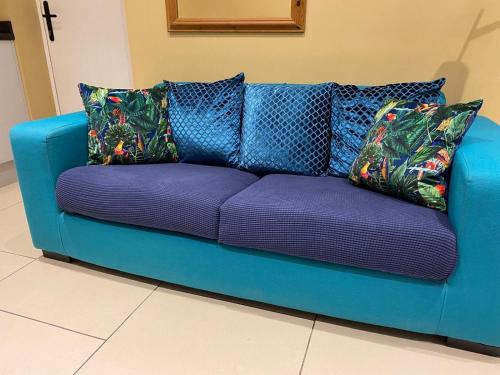 un sofá azul con almohadas en una habitación en Suite near City, Science Park & Marshalls and close to Riverside walks, en Milton