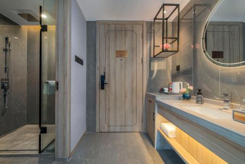 a bathroom with a shower and a sink and a mirror at Morning Hotel, Poyang Sports Center in Boyang