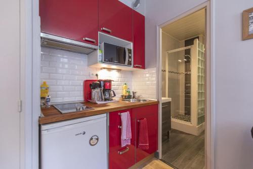 une petite cuisine avec des armoires rouges et un évier dans l'établissement Cauterets Georgina, à Cauterets
