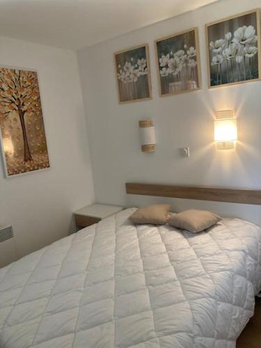 une chambre avec un lit blanc avec deux oreillers dessus dans l'établissement Cannes appt climatisé 5 pers / 9 L, à Cannes