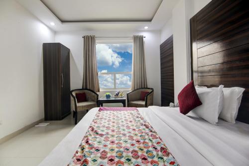 ニューデリーにあるHotel Devrana Delhiの大きなベッドと窓が備わるホテルルームです。
