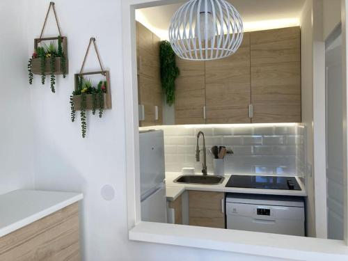 une cuisine avec un évier et un réfrigérateur blanc dans l'établissement Cannes appt climatisé 5 pers / 9 L, à Cannes