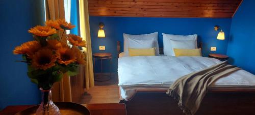 um quarto azul com uma cama e um vaso de flores em GreenHouse s bazenom em Otruševec