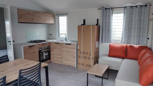 a kitchen and a living room with a couch and a table at Tiny house camping Ambon in Ambon