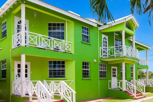a green building with white balconies on it at Best E Villas Prospect St James in Saint James