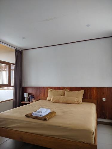 a bedroom with a large bed with a towel on it at Villa Redemptorist in Weetebula