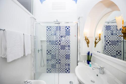 a white bathroom with a shower and a sink at Villa Flavio Gioia in Positano