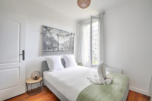 - une chambre blanche avec un lit et une fenêtre dans l'établissement La Vie en Rose - Paris - A 5 min de Paris, à Saint-Maurice