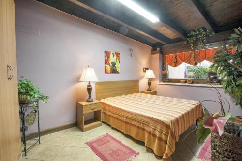 een slaapkamer met een bed, 2 lampen en een raam bij One bedroom house with enclosed garden and wifi at Castellammare del Golfo 2 km away from the beach in Castellammare del Golfo