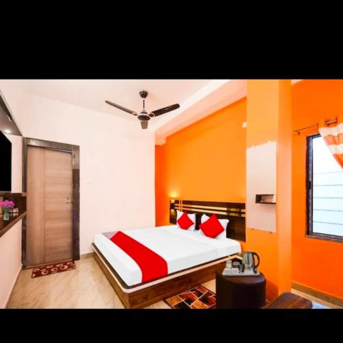 um quarto com uma cama com lençóis vermelhos e brancos em Oyo chinar haven em Salua
