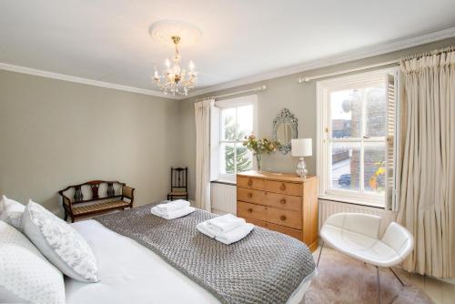 um quarto com uma cama, uma cadeira e uma janela em 3BR Chic House, central Winchester- Sleeps 7! em Winchester