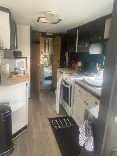 une cuisine avec un évier et une cuisinière four supérieur dans l'établissement La part des anges, à Sainte-Marie-du-Mont