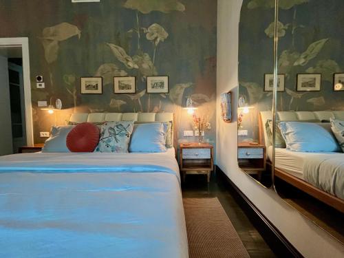 a bedroom with two beds with blue pillows at Villa Lou in Toscolano Maderno