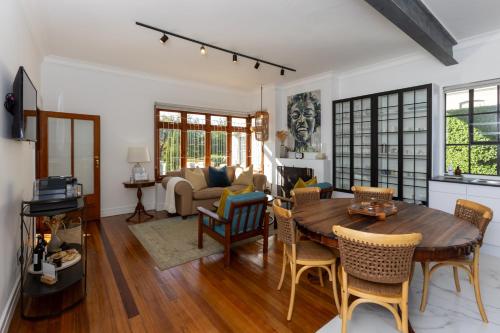 a living room with a wooden table and chairs at La Maison On Main Self-Catering Villa in Paarl