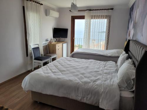 1 dormitorio con 2 camas, escritorio y TV en Terrace Urla en Urla