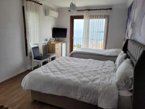 a bedroom with two beds and a desk and a television at Terrace Urla in Urla