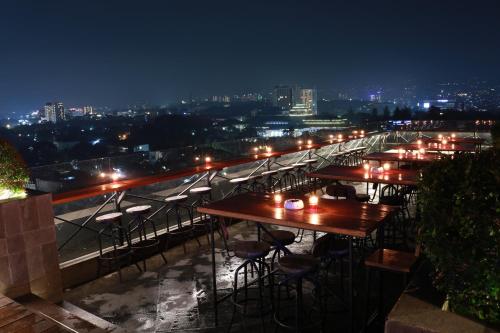 a row of tables on a rooftop at night at De Paviljoen Bandung in Bandung