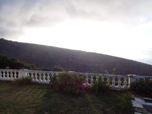 een wit hek in een tuin met een heuvel op de achtergrond bij Valley View in Jamestown