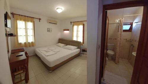 a small bedroom with a bed and a bathroom at Hotel Gulec in Bodrum City