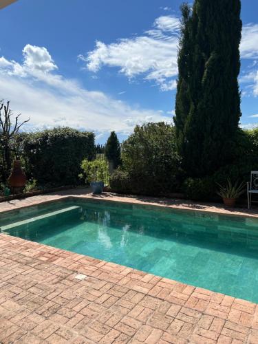 une piscine avec de l'eau bleue dans une cour dans l'établissement L'EPICURE- Zimmer Marsanne, à Vacqueyras