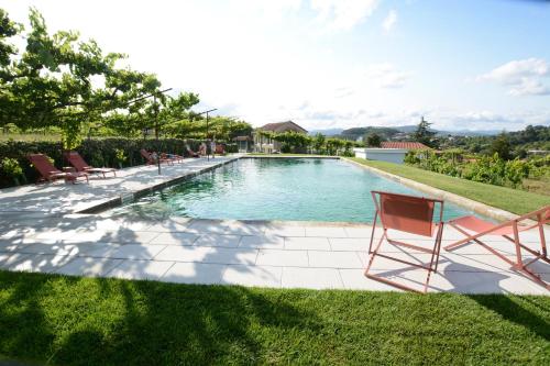 a swimming pool with chairs in a yard at Quinta do Fundo in Mondim de Basto
