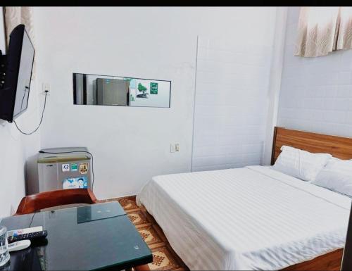 um quarto com uma cama e uma secretária com um computador em Hien CoCo Homestay Hoi An em Hoi An