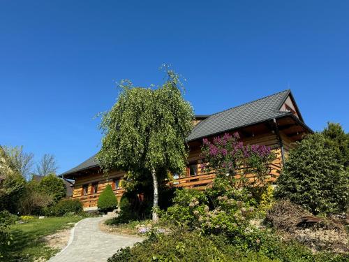 una casa de madera con un camino que conduce a ella en Villa Marlena en Spytkowice