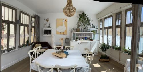 eine Küche mit einem weißen Tisch, Stühlen und Fenstern in der Unterkunft Lark in Schleibnitz
