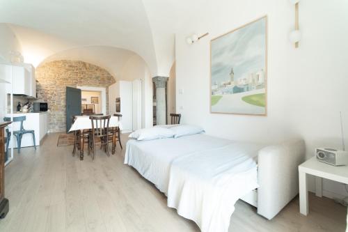 ein weißes Schlafzimmer mit einem Bett und einer Küche in der Unterkunft Il Donizettino in Bergamo