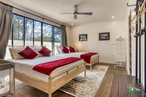 a bedroom with two beds and a large window at Adora's Place - Sleeps 16 in Coron
