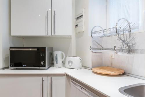 a kitchen counter with a microwave and a sink at Appartement Petits Champs II in Paris