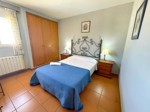 a bedroom with a bed with a blue blanket at Apartamentos Canet de Berenguer 3000 in Canet de Berenguer