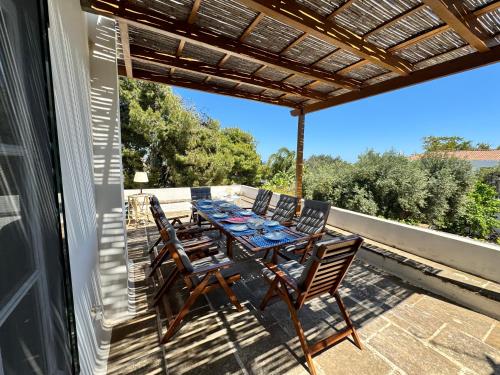 un patio con tavolo e sedie sul balcone. di Two Olive Trees a Spetses