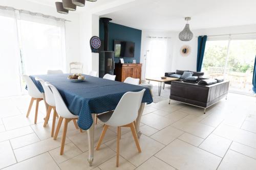 une salle à manger avec une table bleue et des chaises blanches dans l'établissement Escapade en Normandie, à Barneville-sur-Seine