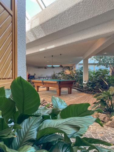 a pool table in the middle of a patio with plants at Hotel Deimann in Schmallenberg