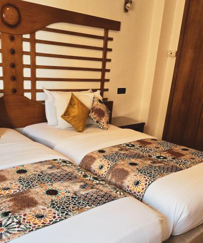 two beds sitting next to each other in a room at Hôtel Rembrandt in Tangier