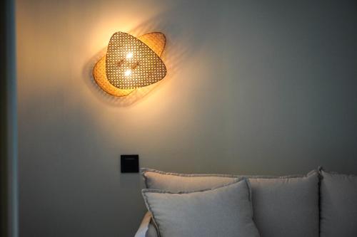 a light fixture on a wall next to a couch at Marins Beach Club - Adults Only Hotel in Cala Millor