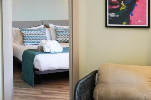 a bedroom with a bed with a teddy bear on it at Marins Beach Club - Adults Only Hotel in Cala Millor