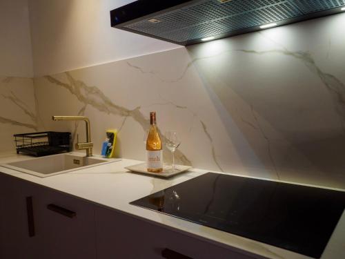 uma cozinha com um lavatório e uma garrafa de champanhe em Apartamentos Casa Cecilia em San Juan de Plan