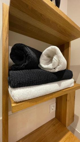 a wooden shelf with black and white towels on it at Traumplatz im Allgäu in Rettenberg