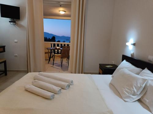 a hotel room with a bed with towels on it at Pouliezos Koklanis Zante Apartments in Alykes