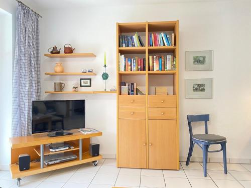 a room with a desk and a tv and a book shelf at Haus Claudia in Zingst