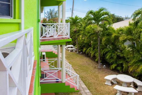 a green and pink building with stairs and a balcony at Best E Villas Prospect St James in Saint James