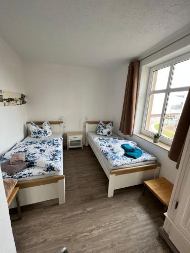 a room with two beds and a window at Pension zum goldenen Anker in Wittenberge