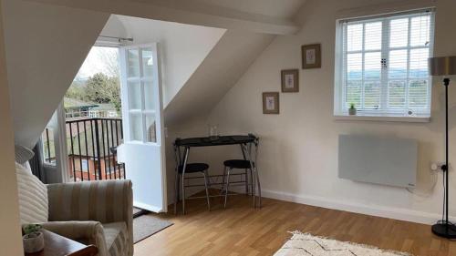 a living room with a table and a window at Stunning 1-Bed Apartment in the Heart of Ludlow in Ludlow
