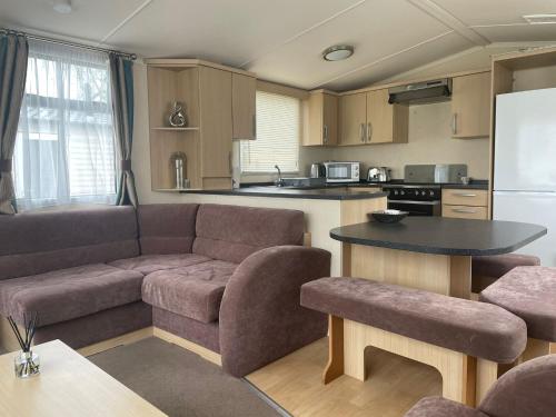 a living room with a couch and a table in a kitchen at Swift Holiday Caravan Rockley Park in Lytchett Minster