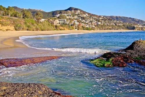 a view of a beach with rocks and the ocean at Laguna Condo w/ Pool/Jacuzzi and Attached Garage in Laguna Niguel