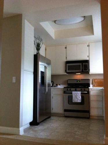 a kitchen with a stainless steel refrigerator and microwave at Laguna Condo w/ Pool/Jacuzzi and Attached Garage in Laguna Niguel