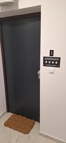 a black bathroom stall with a brown rug in front of it at Apartman SIMON-CENTAR in Nova Gradiška