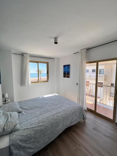 a bedroom with a bed and a large window at Bioca l Apartamento 2 habitaciones I Primera Línea de Playa l Peñíscola in Peñíscola